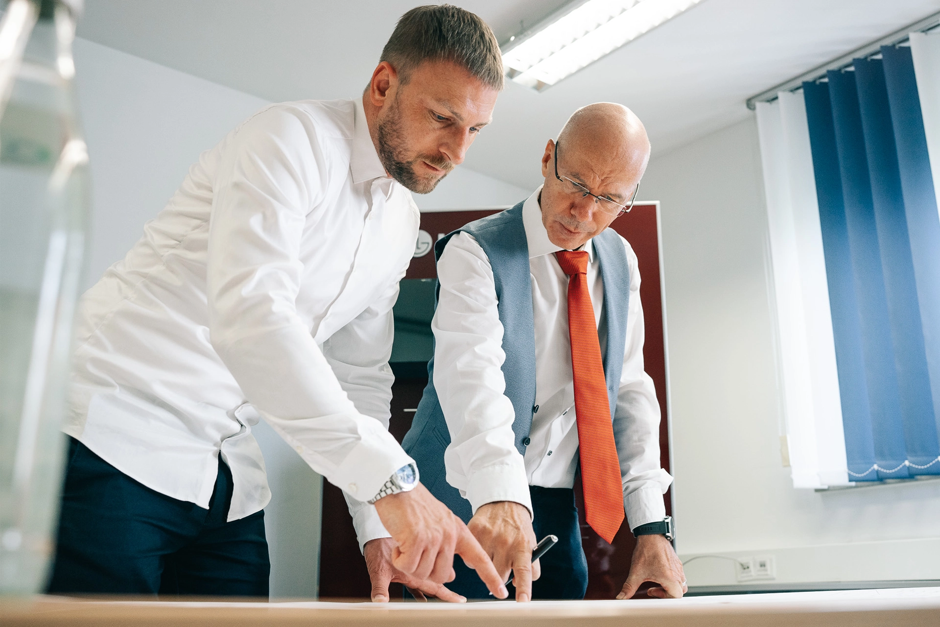Zwei Personen im Business-Outfit bei einer Besprechung, Symbol für berufliches Vorankommen