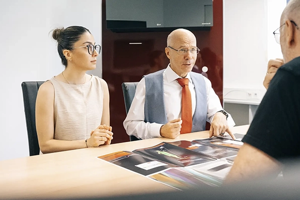 Zwei Personen in einem Business-Meeting, diskutieren technische Dokumente von Klimatechnik Wagner aus Augsburg.