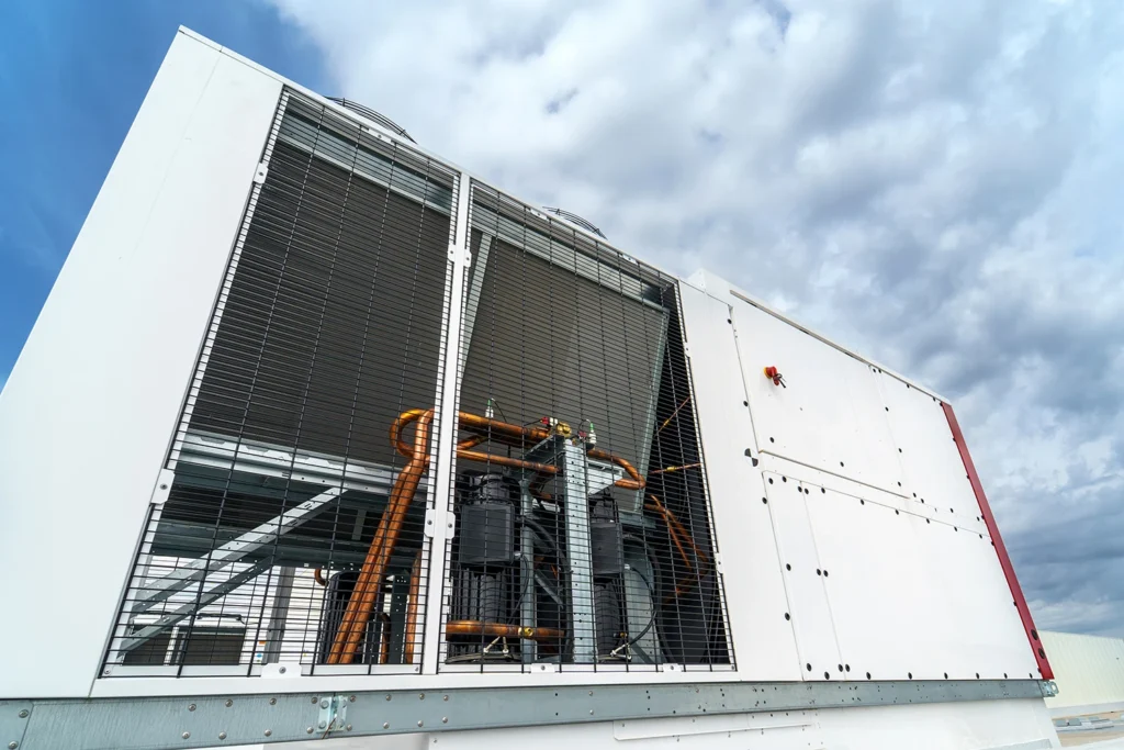 Große industrielle Kältemaschine mit sichtbaren Kupferrohren auf einem Dach – eine typische Anlage für Leihkälte.